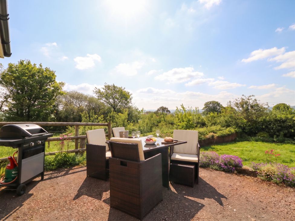 An outdoor area with a table and chairs at Palace Bungalow in St Weonards