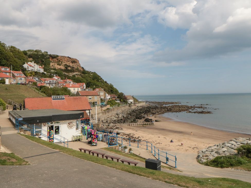 A beach with rocks and a shop at Primrose Lodge Runswick Bay near Staithes