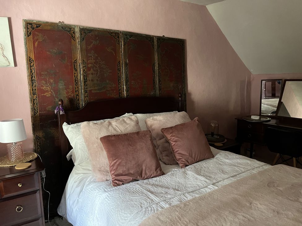 A bedroom with a bed and a dressing table at 4 Cumberland Cottages Ringmore near Challaborough