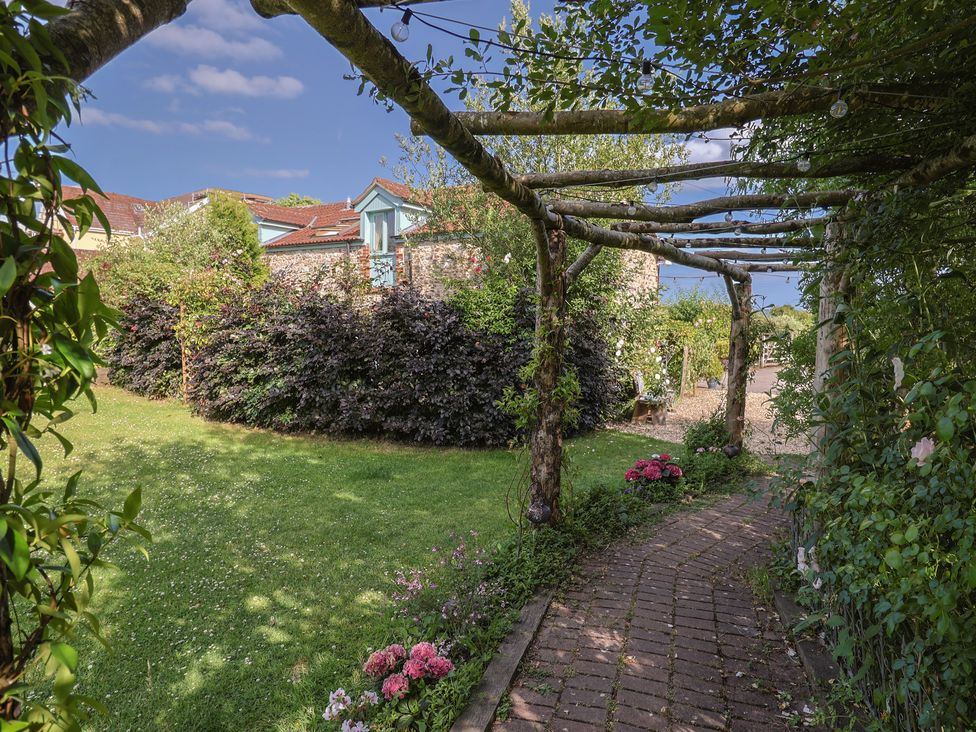 A garden with a pathway and flowers at The Calf Pen in Colyton