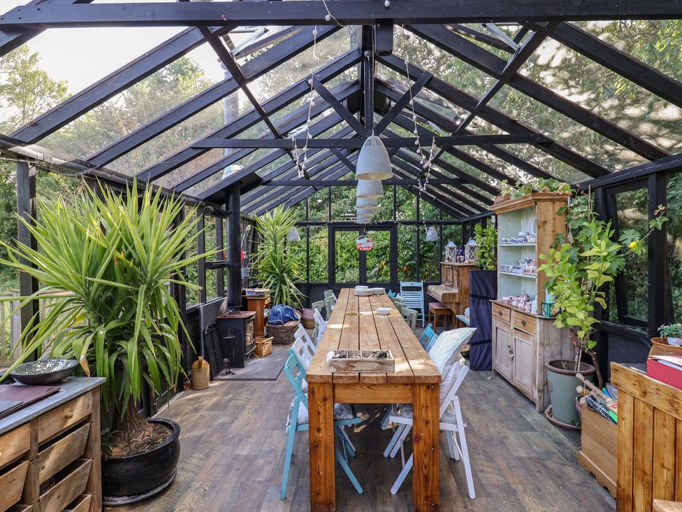 A dining room with a long table and chairs at The Bull Pen in Colyton