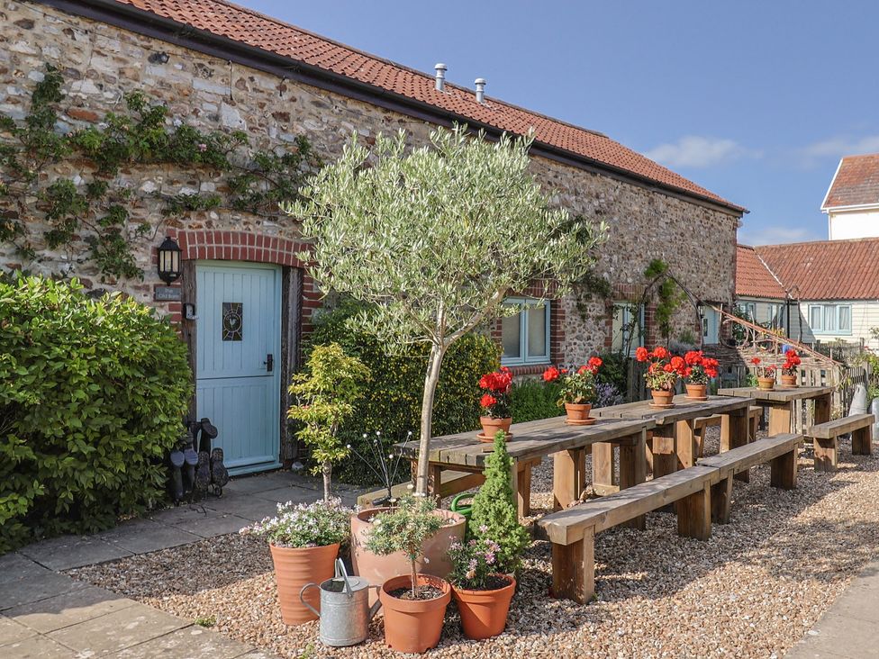 An outdoor area with plants and a wooden table at The Bull Pen in Colyton