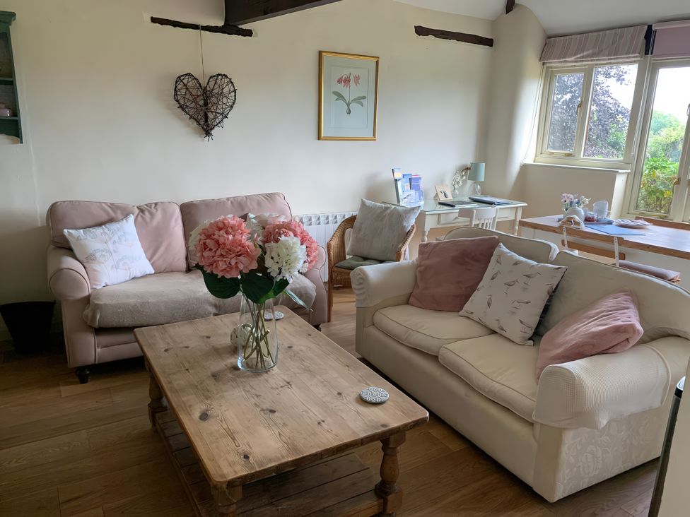 A living room with a couch and coffee table at The Bull Pen in Colyton