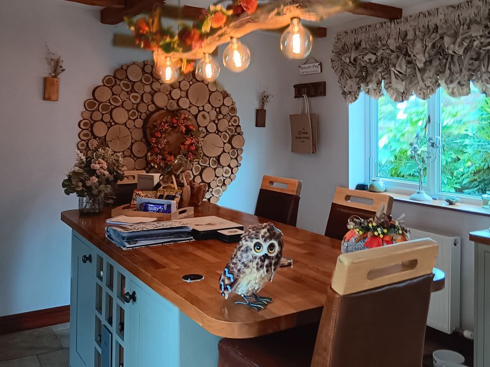 A kitchen with a wooden table and chairs at Tawny Owl Cottage in North Somercotes