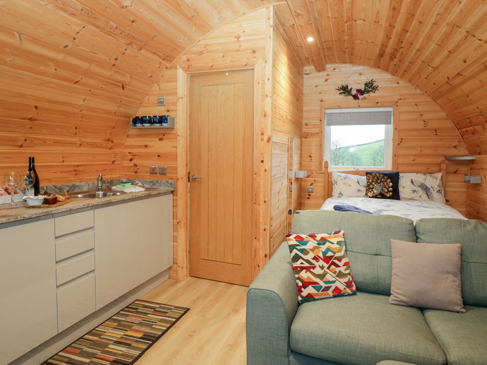 A living room with a kitchen and bed at Holly in Ulverston