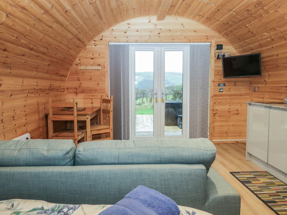 An interior view of a pod with a sofa and dining area at Holly in Ulverston