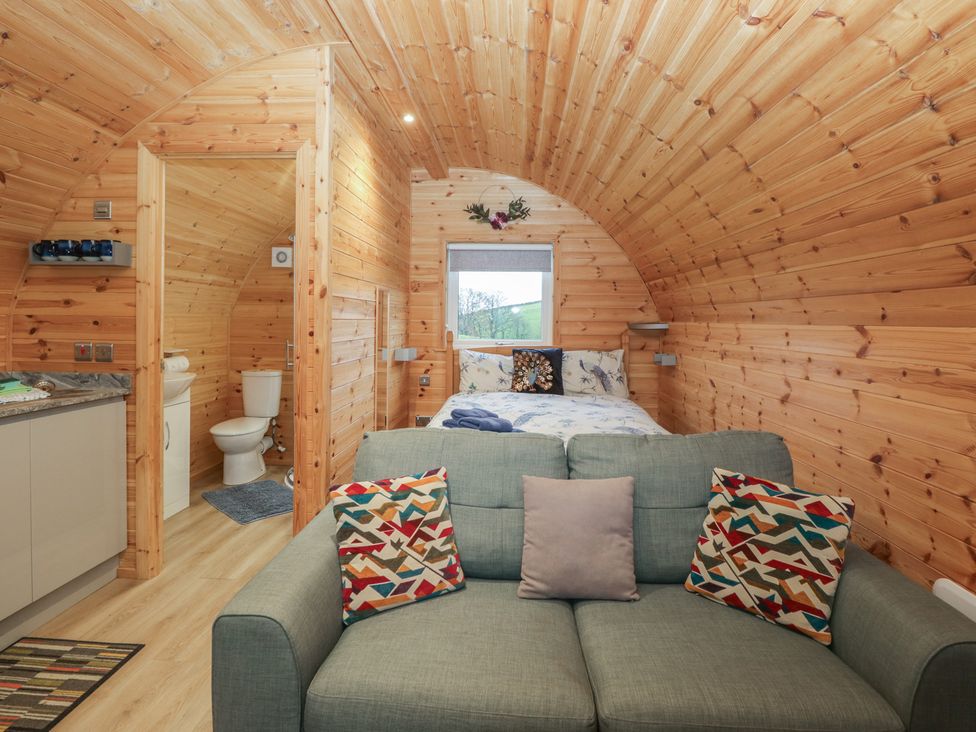 A bedroom with a sofa and bed at Holly in Ulverston