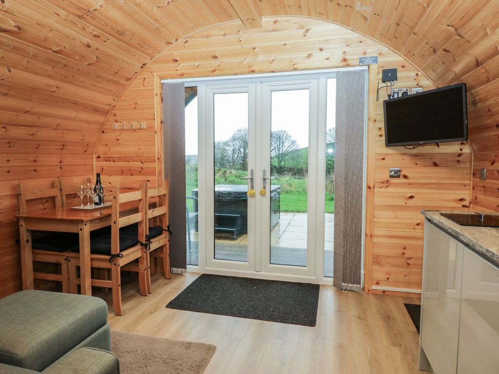 A dining area with a table and chairs and a sliding door at Willow in Ulverston