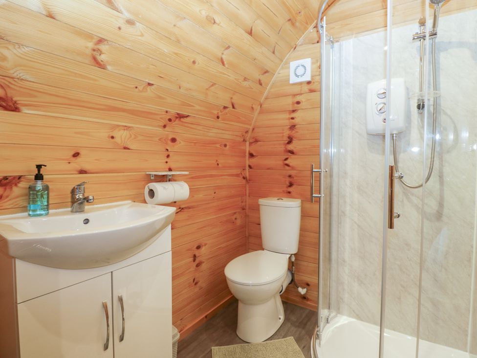 A bathroom with a sink, toilet, and shower at Oak in Ulverston