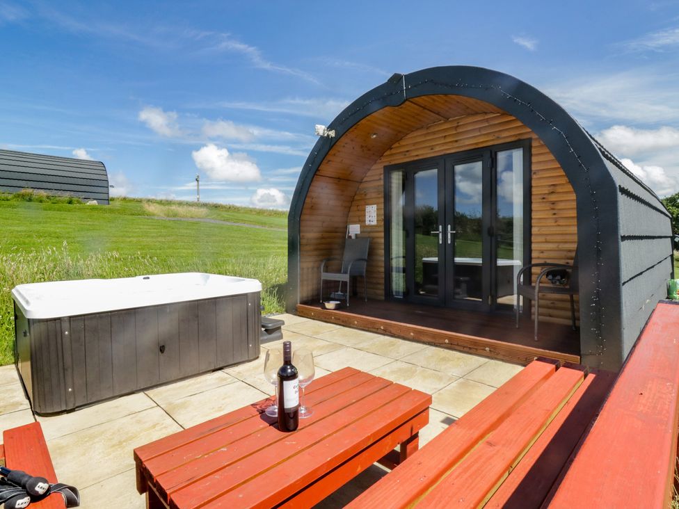 An outdoor seating area with a hot tub and table at Oak in Ulverston