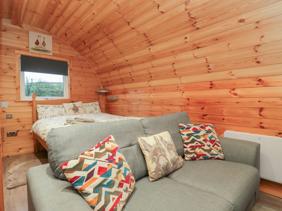 A bedroom with a bed and a sofa at Rowan in Ulverston