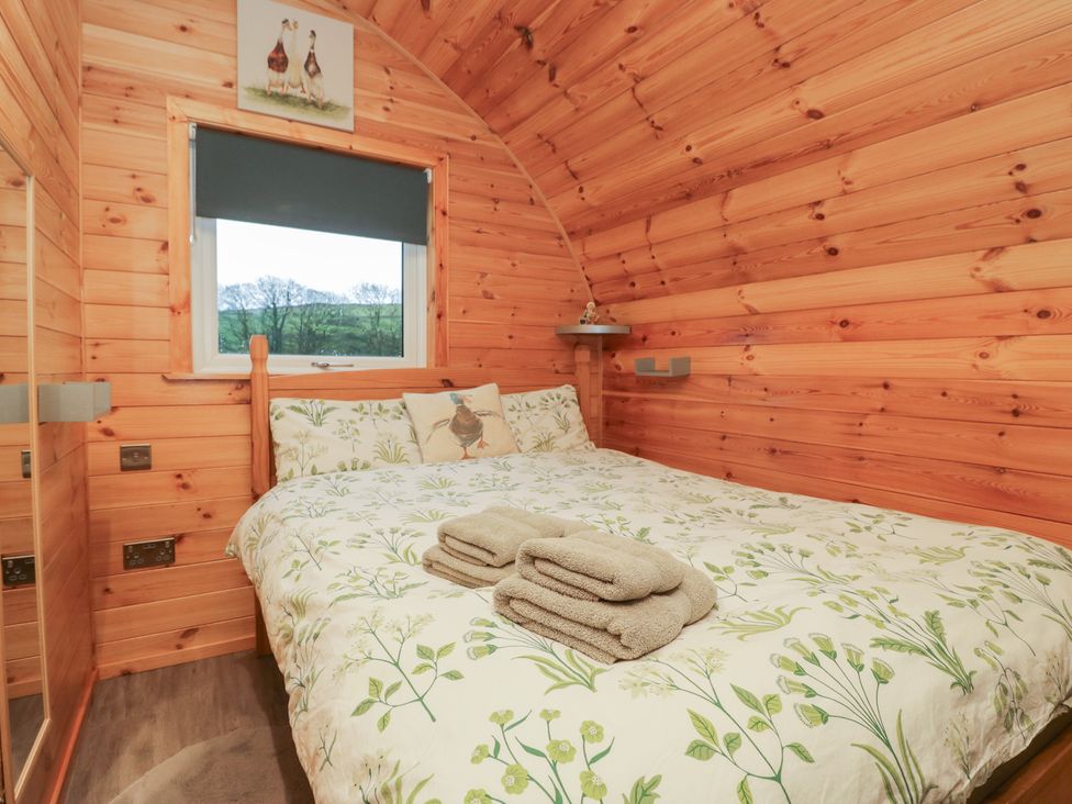 A bedroom with a bed and towels on a bedside at Rowan in Ulverston