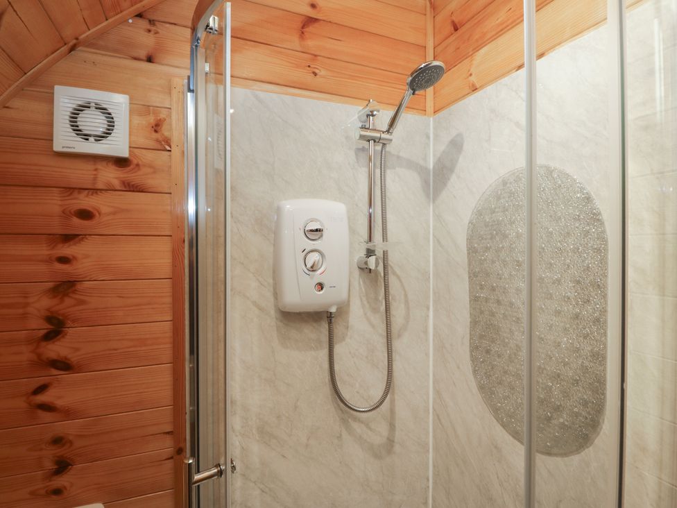 A shower with a control unit and tiled wall at Rowan in Ulverston