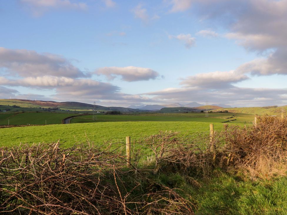 A view of fields and mountains under a cloudy sky at Rowan in Ulverston