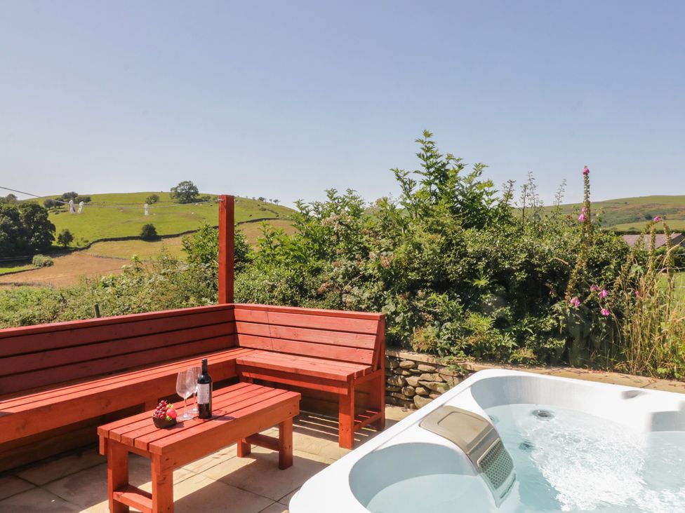 An outdoor space with a hot tub and seating area at Rowan in Ulverston