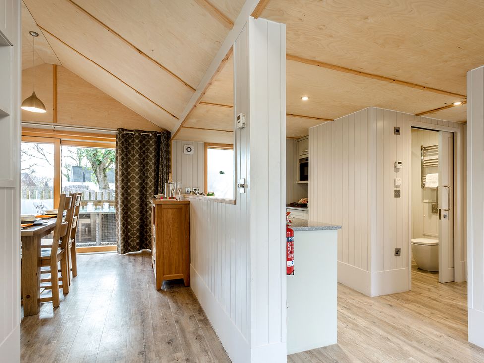 A kitchen with dining area and access to the bathroom at Lodge 14 Corfe Castle