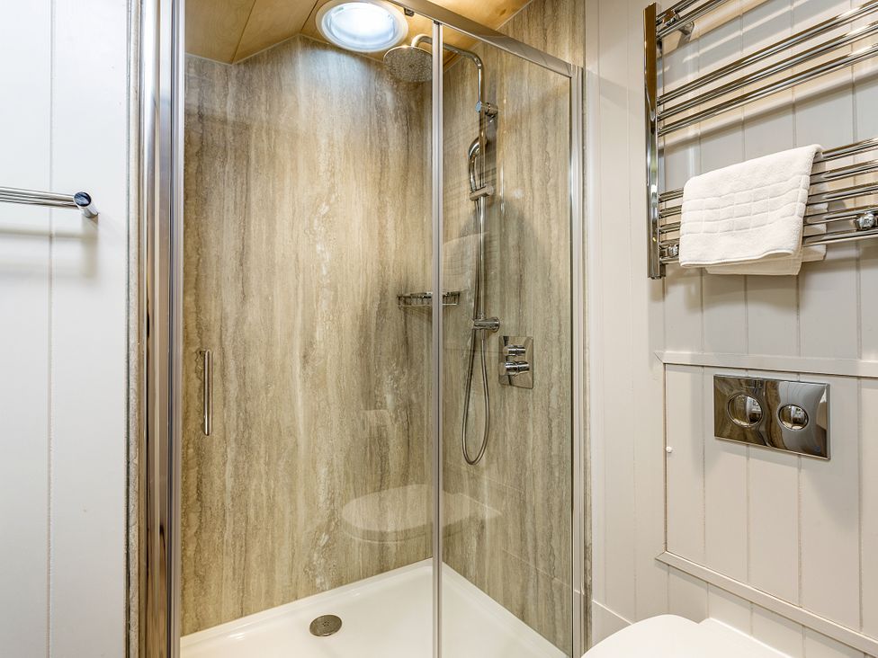 A bathroom with a shower and towel rail at Lodge 17 in Corfe Castle