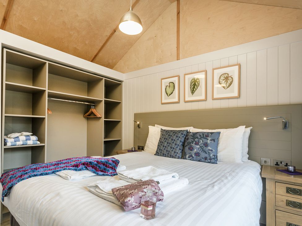 A bedroom with a bed and storage at Lodge 17 in Corfe Castle