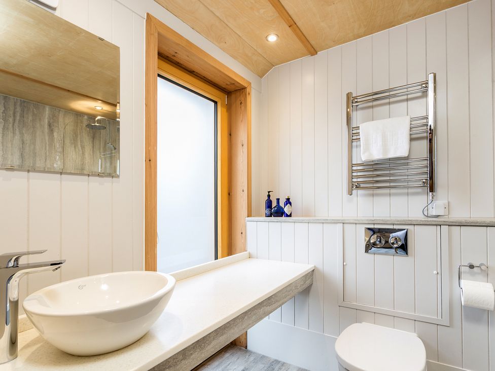 A bathroom with sink, toilet, and towel rack at Lodge 17 in Corfe Castle
