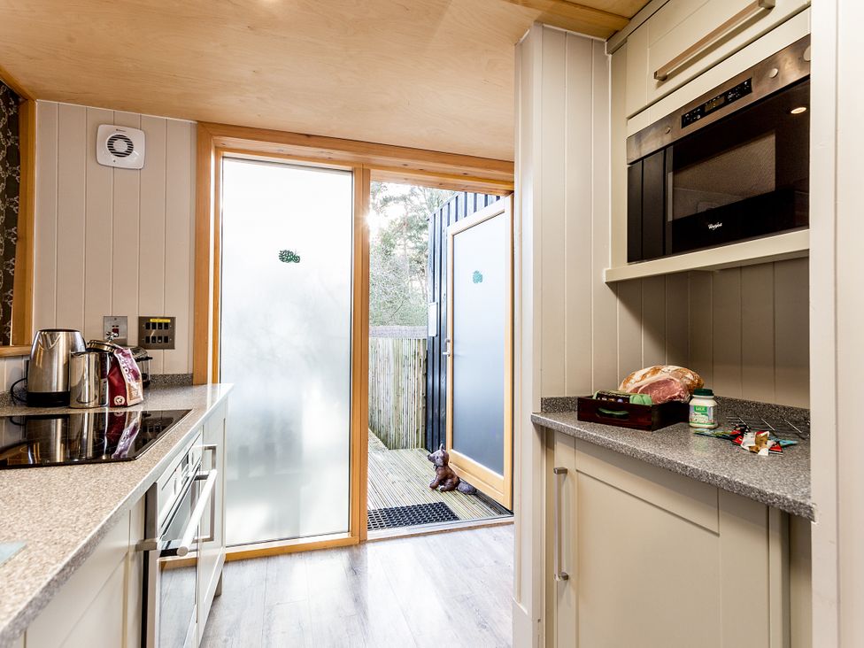 A kitchen with appliances and a door leading outside at Lodge 18 in Corfe Castle