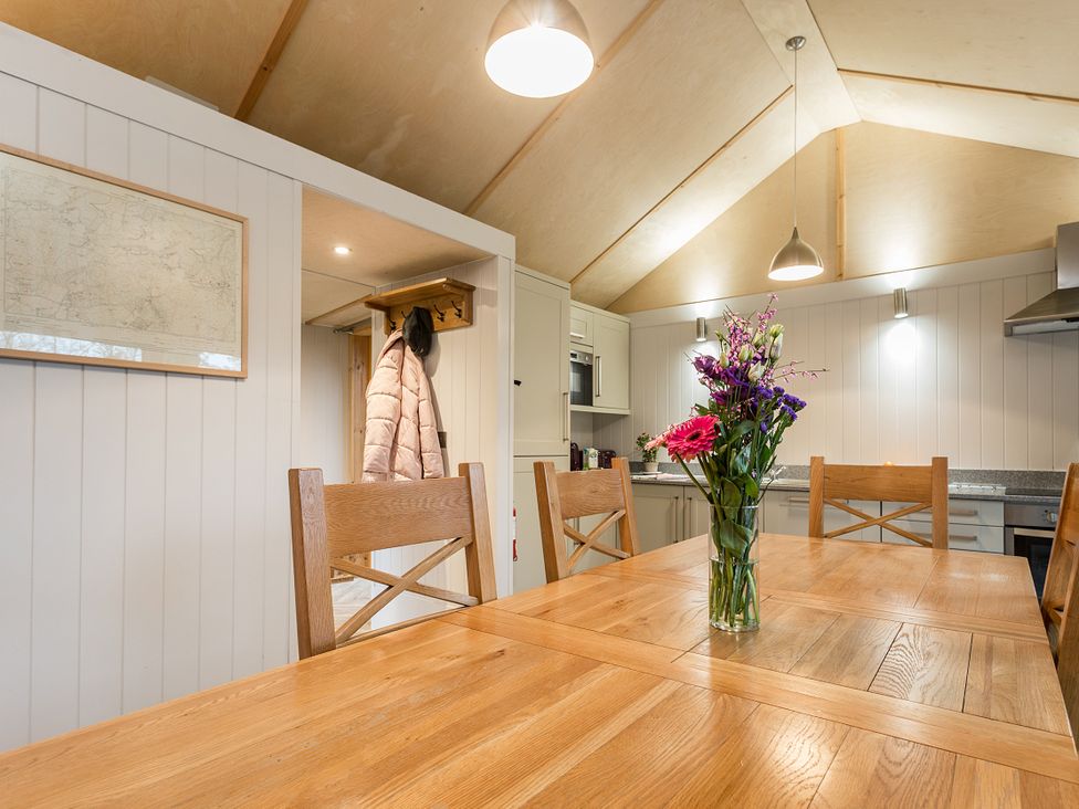 A kitchen with a dining table and flower vase at Lodge 19 in Corfe Castle