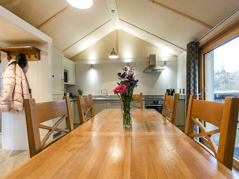 A kitchen with a dining table and flower vase at Lodge 19 Corfe Castle