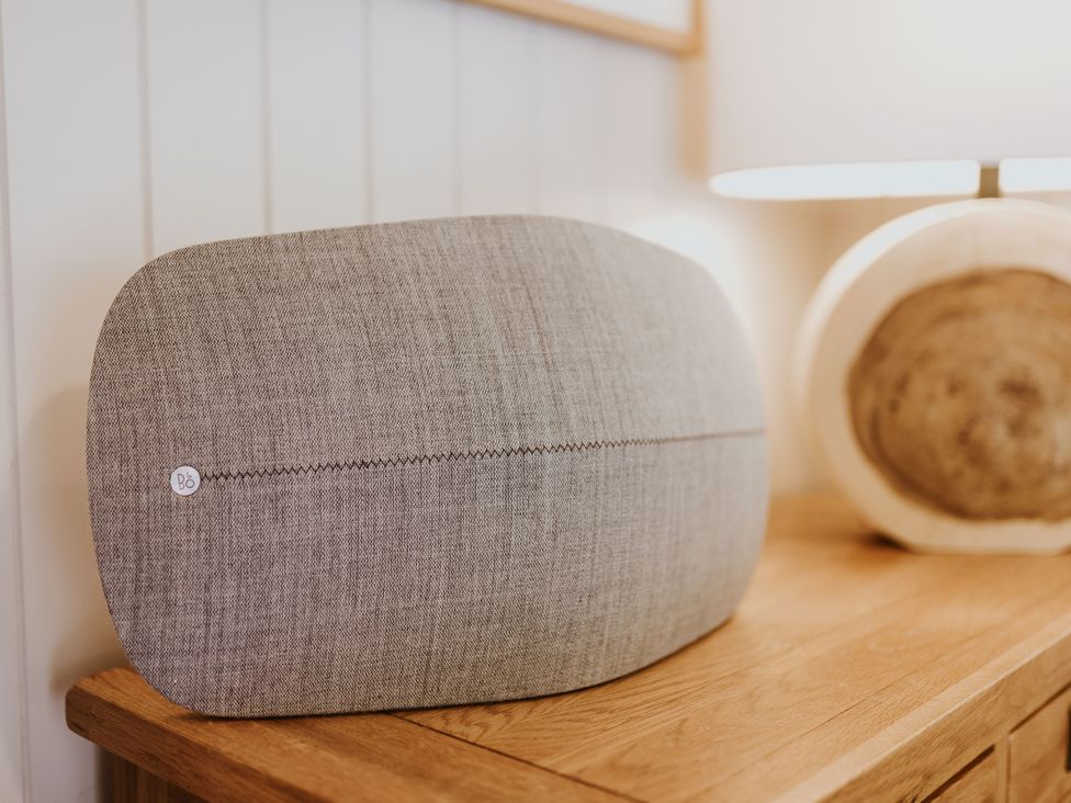 A cushion on a wooden table with a lamp at Lodge 19 in Corfe Castle