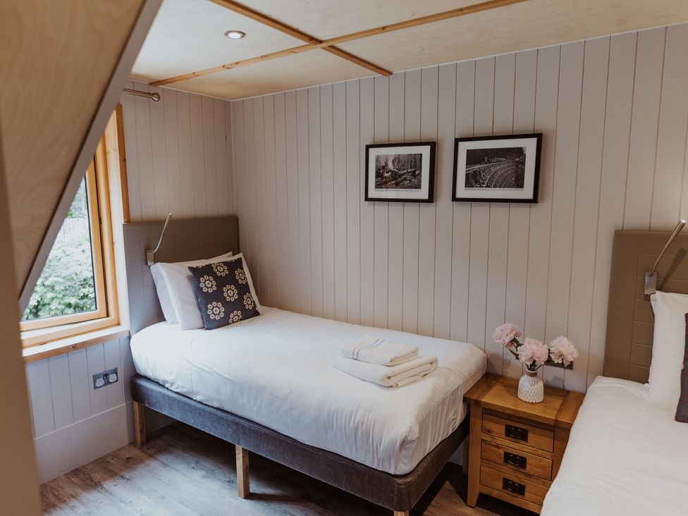 A bedroom with two beds and a bedside table at Lodge 19 in Corfe Castle