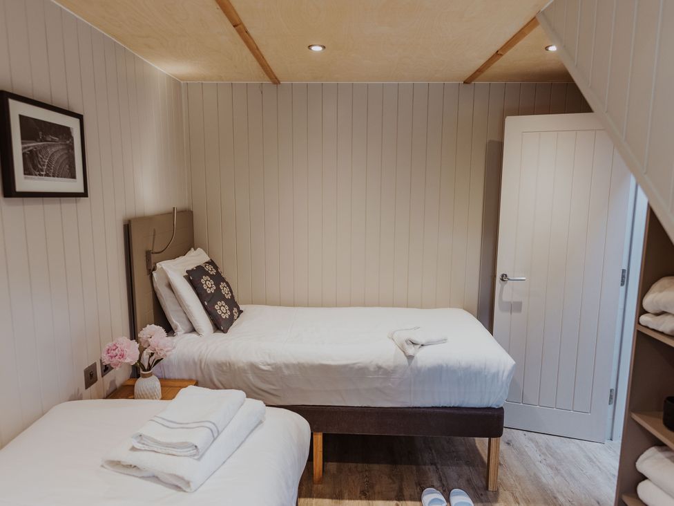 A bedroom with two beds and a nightstand at Lodge 19 Corfe Castle