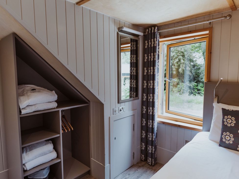 A bedroom with a window and storage at Lodge 19 in Corfe Castle