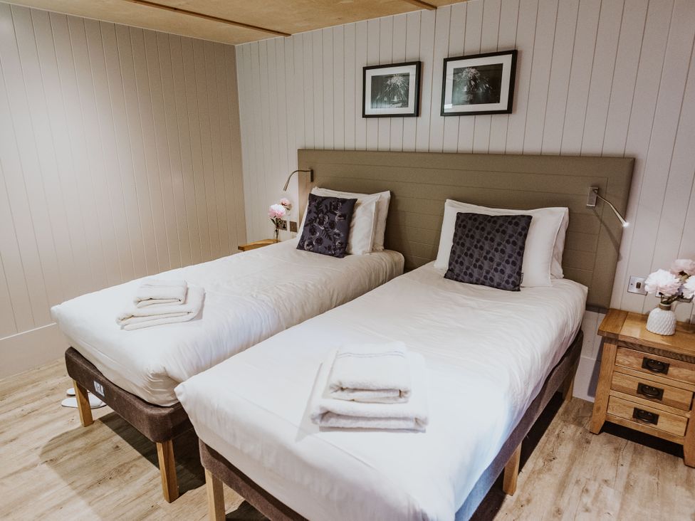 A bedroom with two beds and a bedside table at Lodge 19 in Corfe Castle