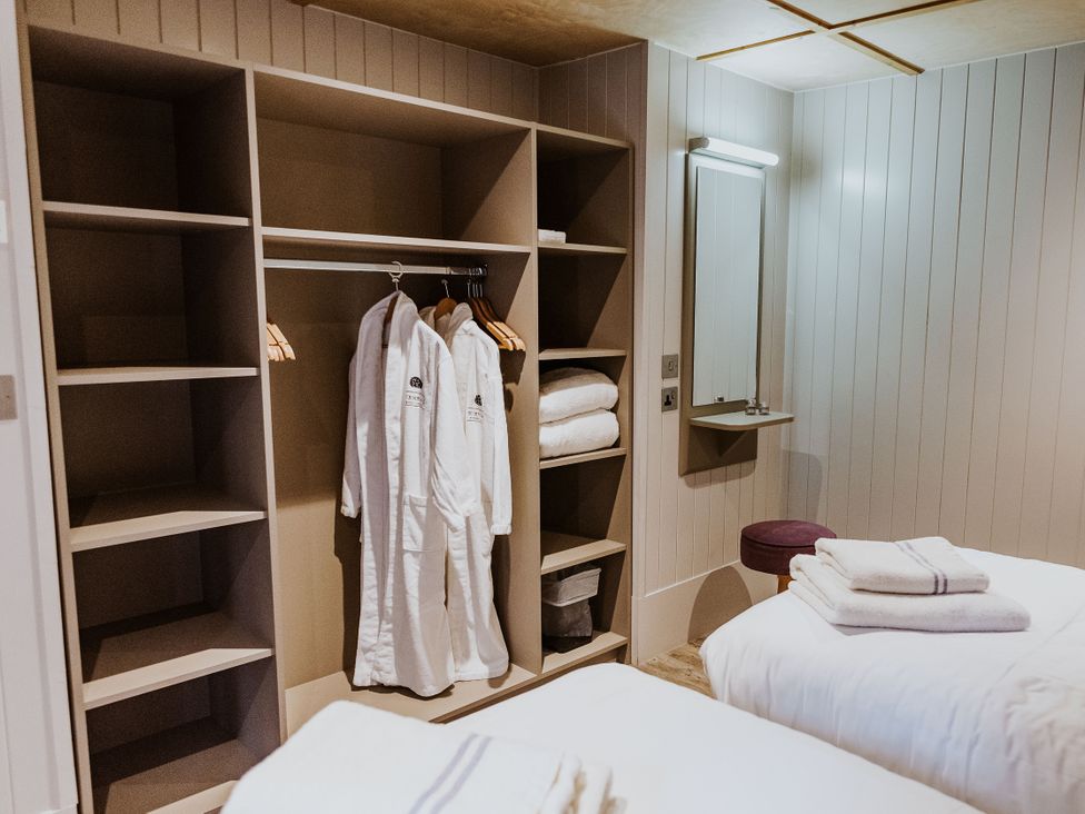 A bedroom with wardrobes and towels at Lodge 19 Corfe Castle