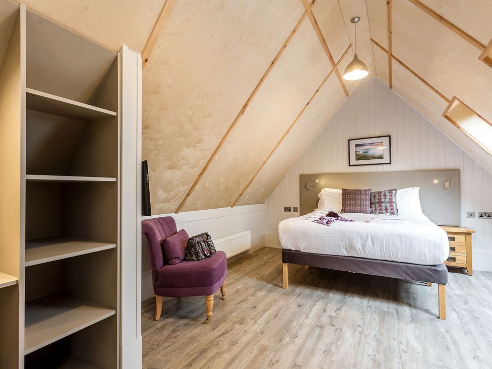A bedroom with a bed and a chair at Lodge 19 in Corfe Castle