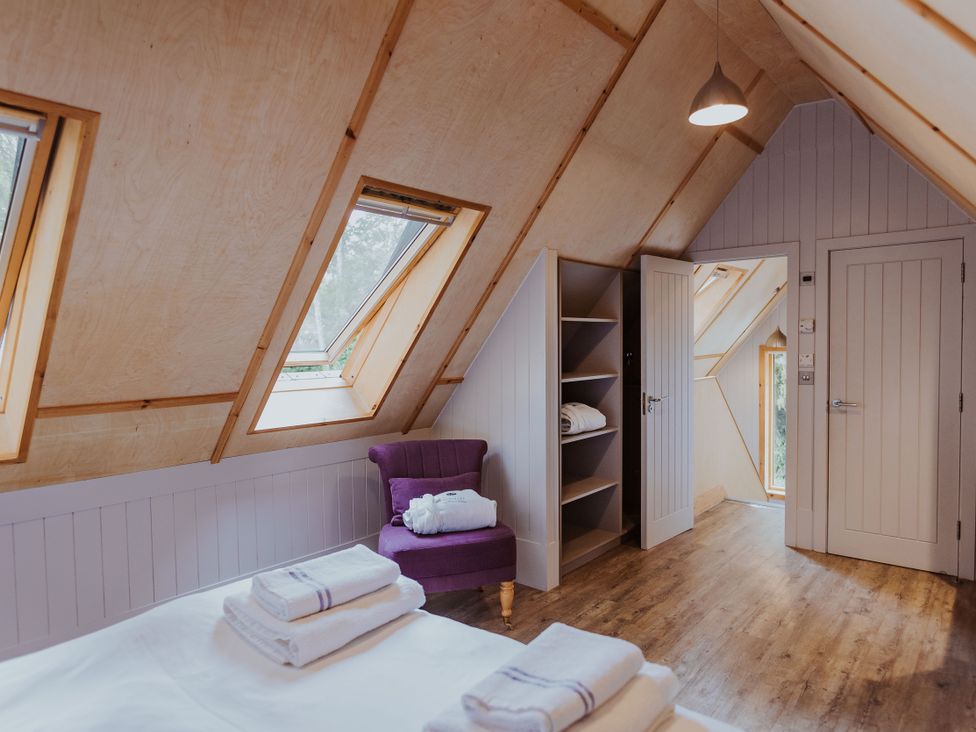 A bedroom with a bed and shelves at Lodge 19 in Corfe Castle