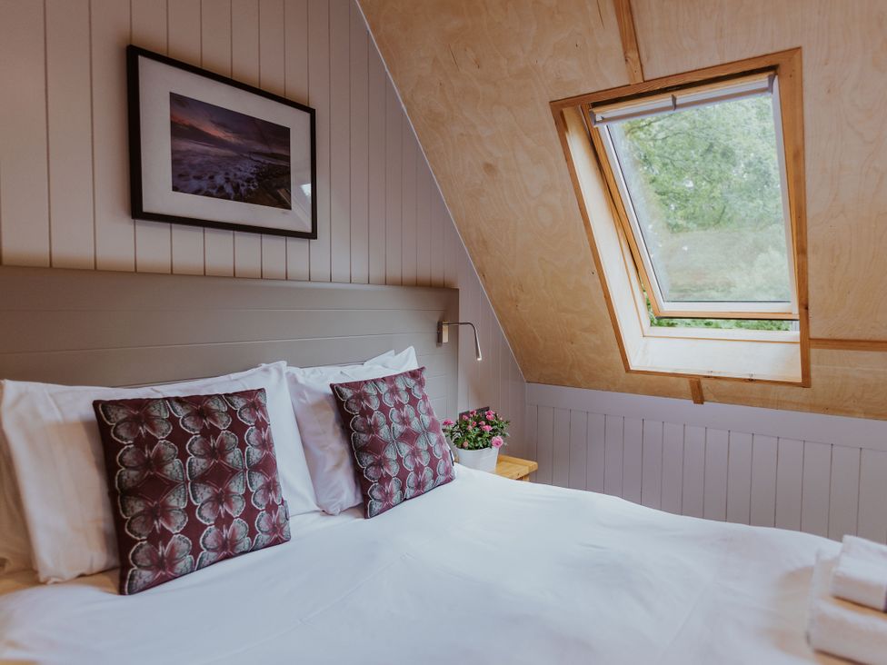 A bedroom with a bed and skylight at Lodge 19 in Corfe Castle