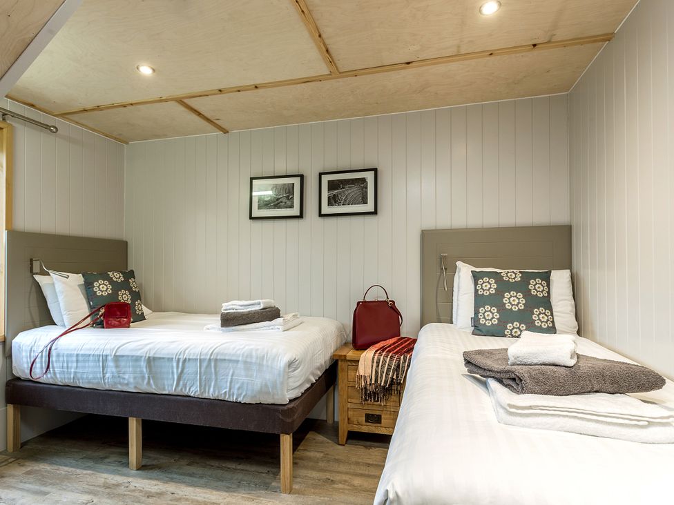 A bedroom with two beds and decorative items at Lodge 19 in Corfe Castle