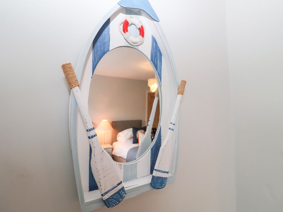 A mirror designed as a boat with oars in a bedroom at Elkhorn Southwold