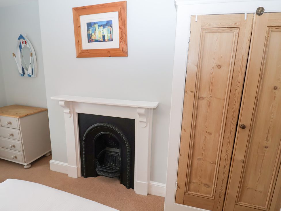 A bedroom with a fireplace and wardrobe at Elkhorn in Southwold
