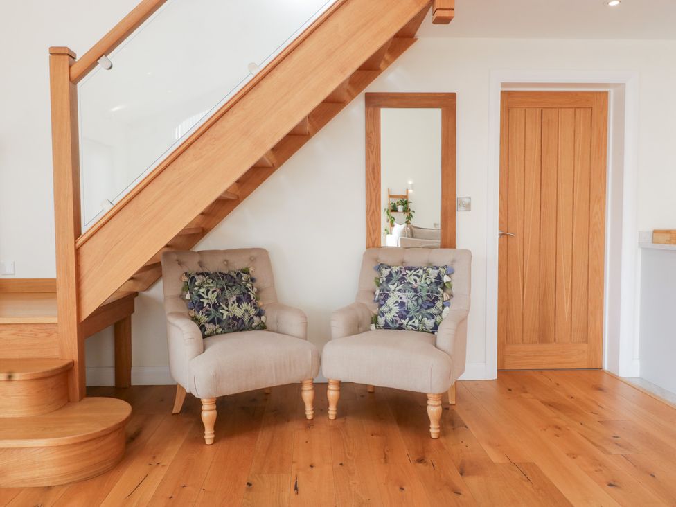 A sitting room with two chairs and a staircase at Bilsham Meadows in Aust