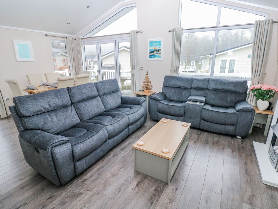 A living room with a sofa and coffee table at Dono's Lodge Stepaside near Kilgetty Heritage Park