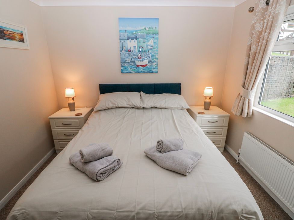 A bedroom with a bed and nightstands at Dono's Lodge, Stepaside near Kilgetty, Heritage Park