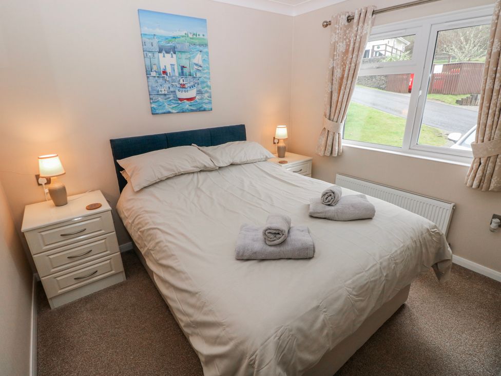 A bedroom with a bed and bedside tables at Dono's Lodge, Stepaside near Kilgetty, Heritage Park