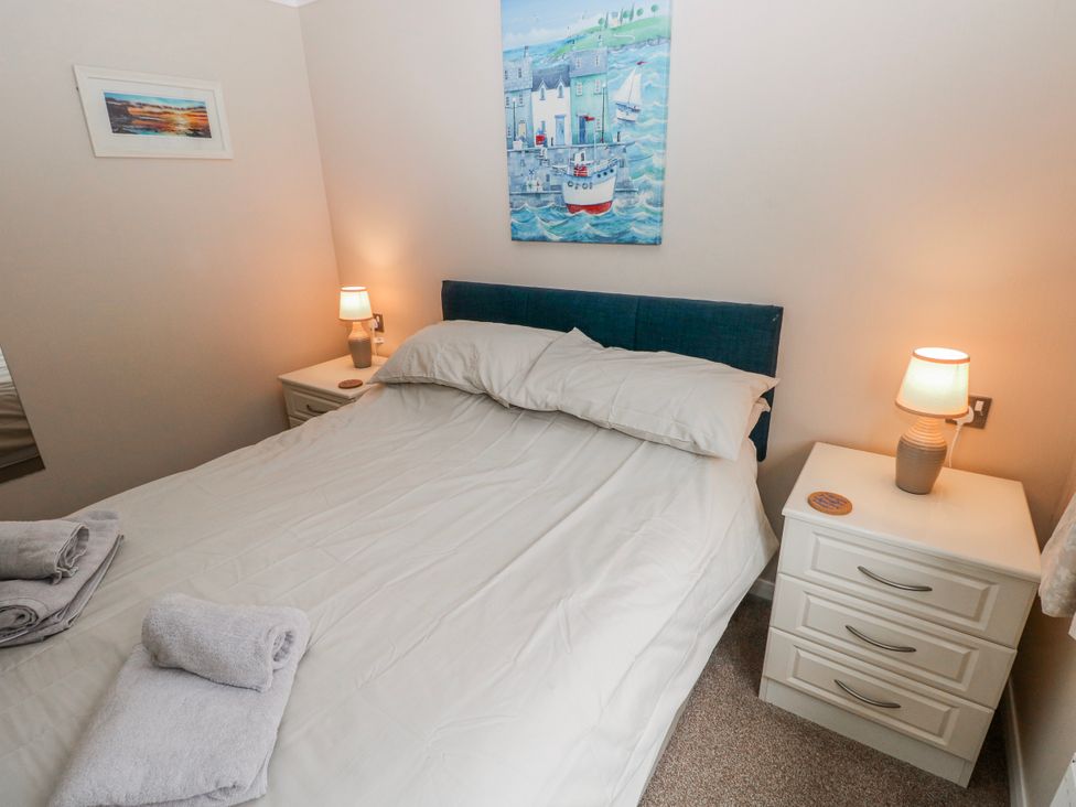 A bedroom with a bed and bedside tables at Dono's Lodge, Stepaside near Kilgetty, Heritage Park