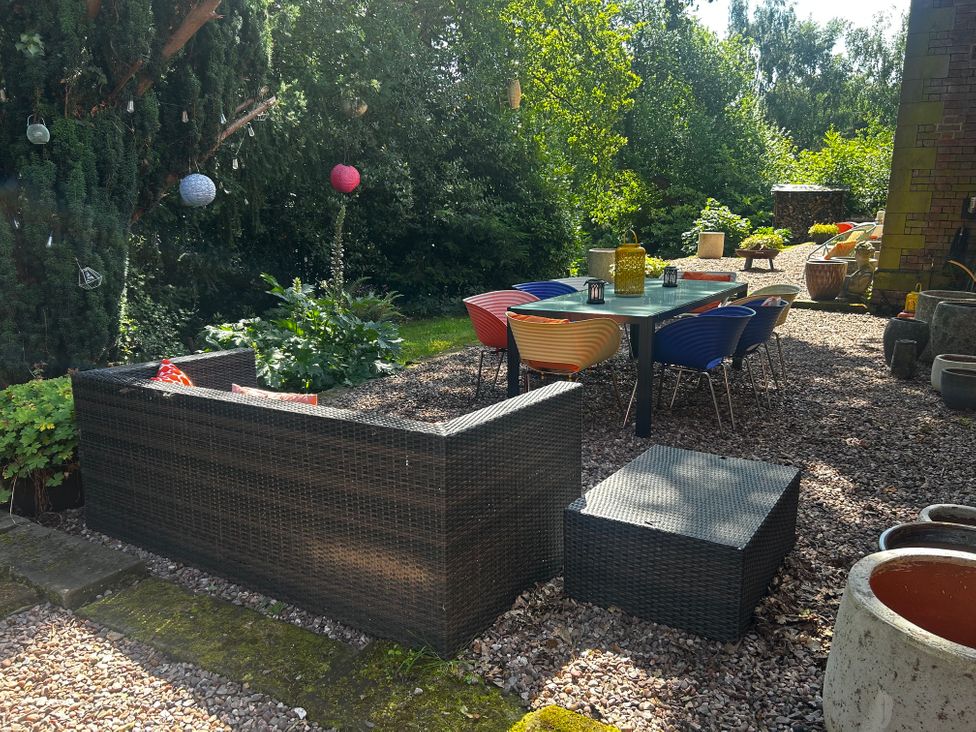 An outdoor seating area with a table and chairs at Chetwynd Lodge Ingestre near Great Haywood