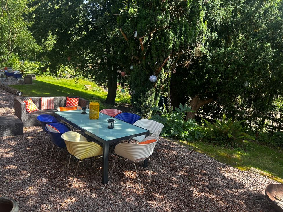 A garden with an outdoor table and chairs at Chetwynd Lodge Ingestre near Great Haywood