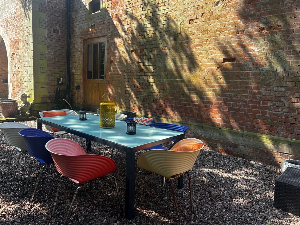A table with chairs and lanterns in a patio area at Chetwynd Lodge Ingestre near Great Haywood