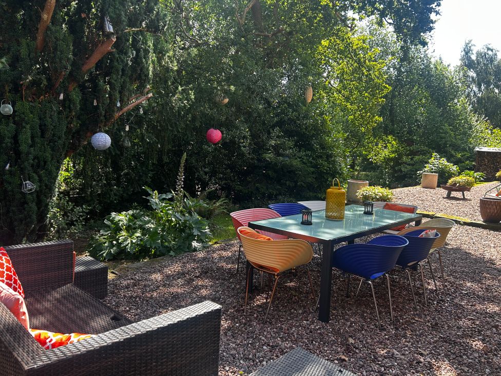 A garden with a seating area and table at Chetwynd Lodge Ingestre near Great Haywood