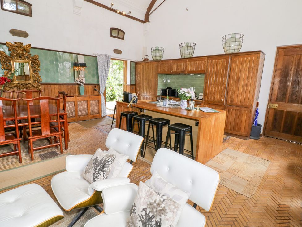 A kitchen with a dining area and wooden cabinets at Chetwynd Lodge Ingestre near Great Haywood