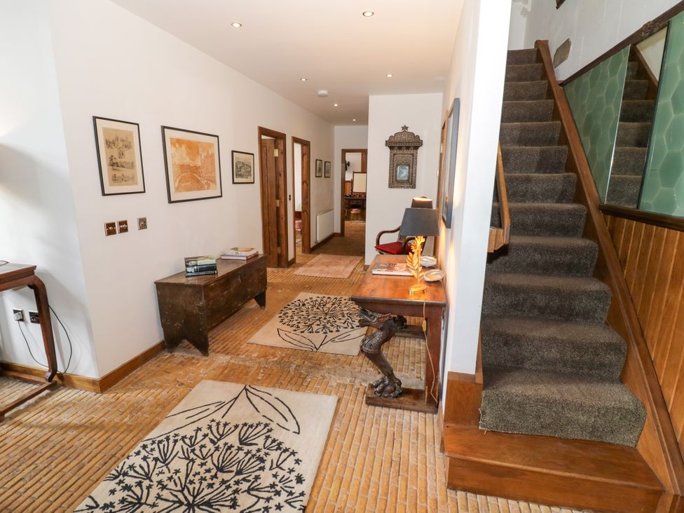A hallway with a staircase and table at Chetwynd Lodge Ingestre near Great Haywood
