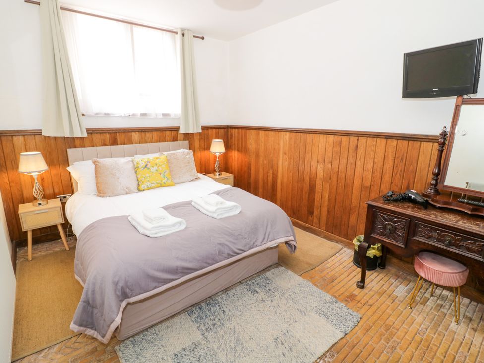 A bedroom with a double bed and a dressing table at Chetwynd Lodge Ingestre near Great Haywood